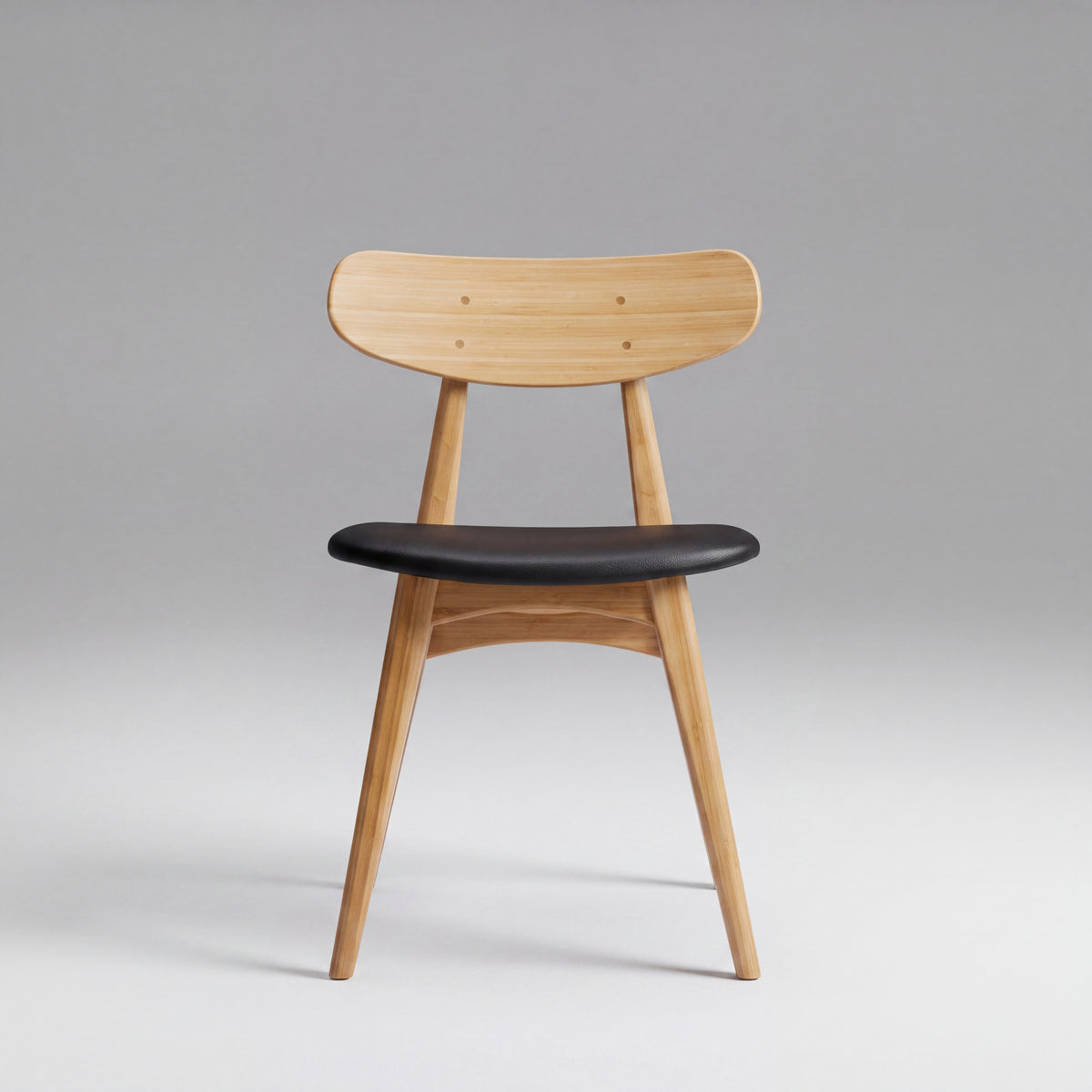 Greenington Cassia Dining Chair in Caramelized bamboo with a black leather seat, on a grey studio background, front view