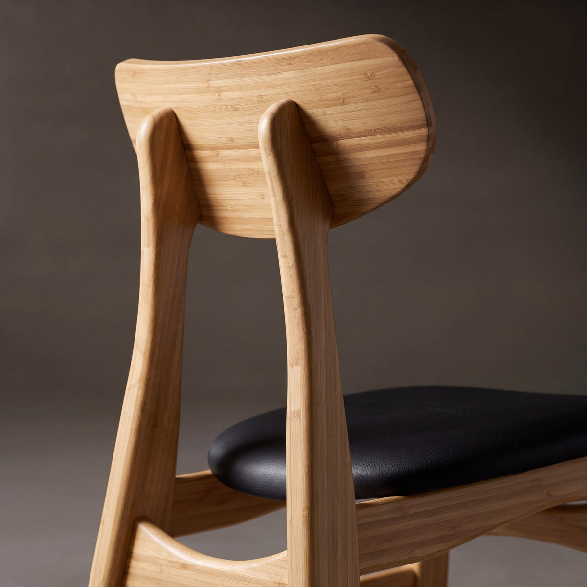 Greenington Cassia Dining Chair in Caramelized bamboo with a black leather seat, close-up of the backrest and seat
