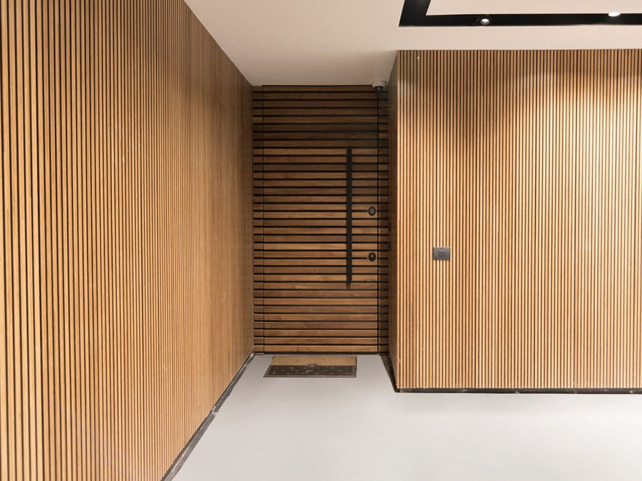 Solid bamboo slat wall panels lining an entry hall, with a matching slatted bamboo door