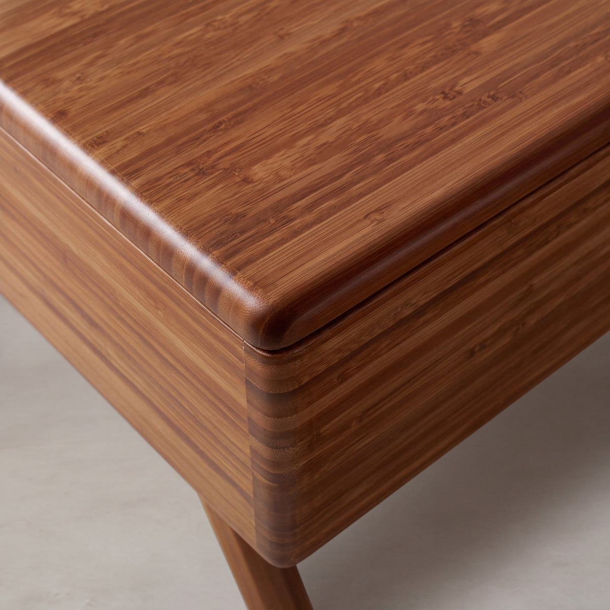 Close-up of the top and bamboo grain on the Greenington Rhody Lift Top Coffee Table in Amber bamboo
