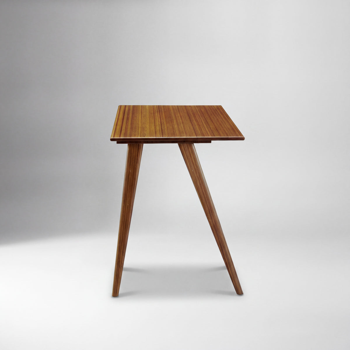 Greenington Studio Plus Desk in Amber bamboo, studio photo on a plain background
