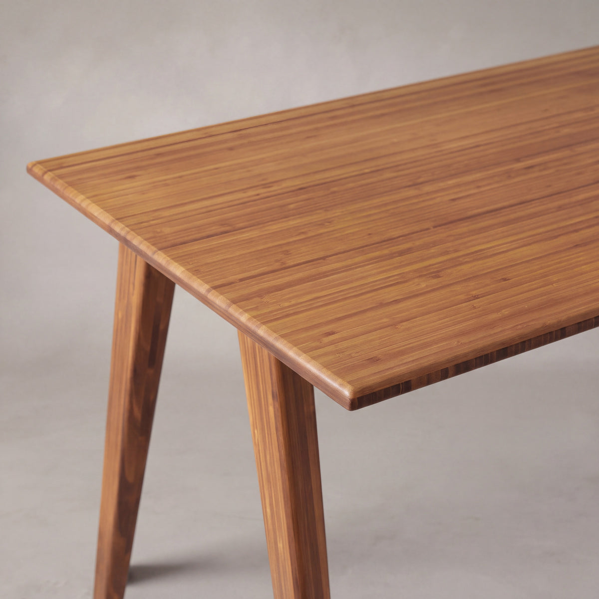 Close-up of the top and bamboo grain on the Greenington Studio Plus Desk in Amber bamboo