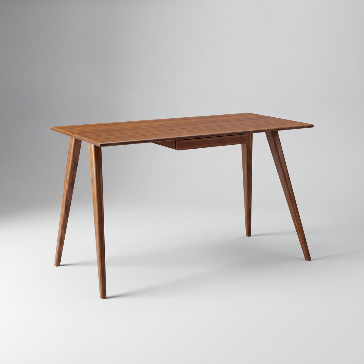 Greenington Studio Plus Desk in Amber bamboo, on a studio background
