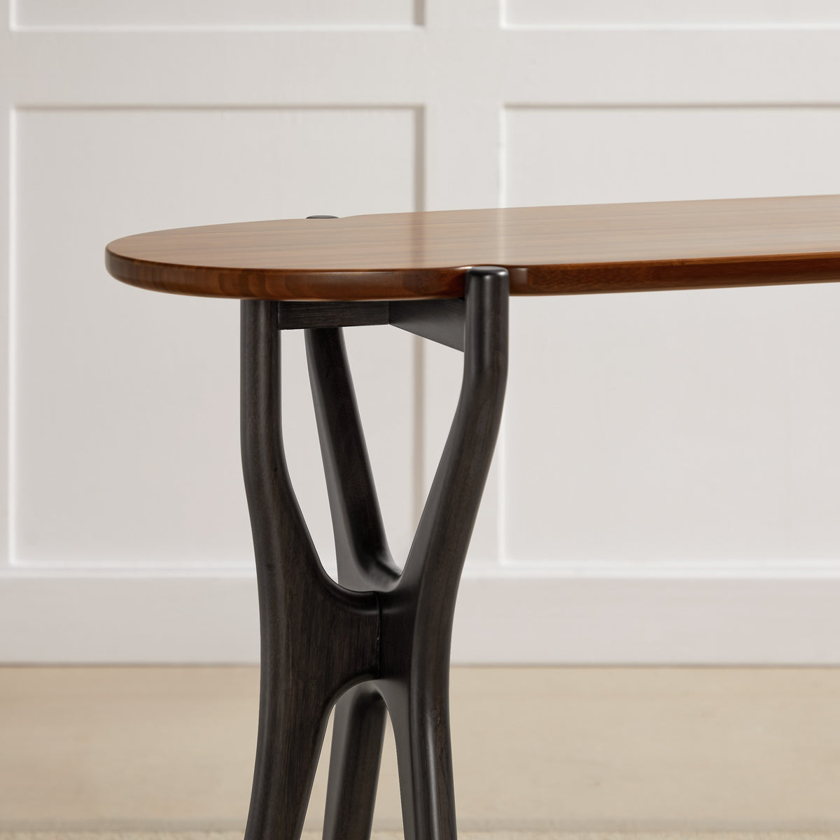 The leg of the Greenington Tofino Console Table in Amber and Caviar bamboo, up close
