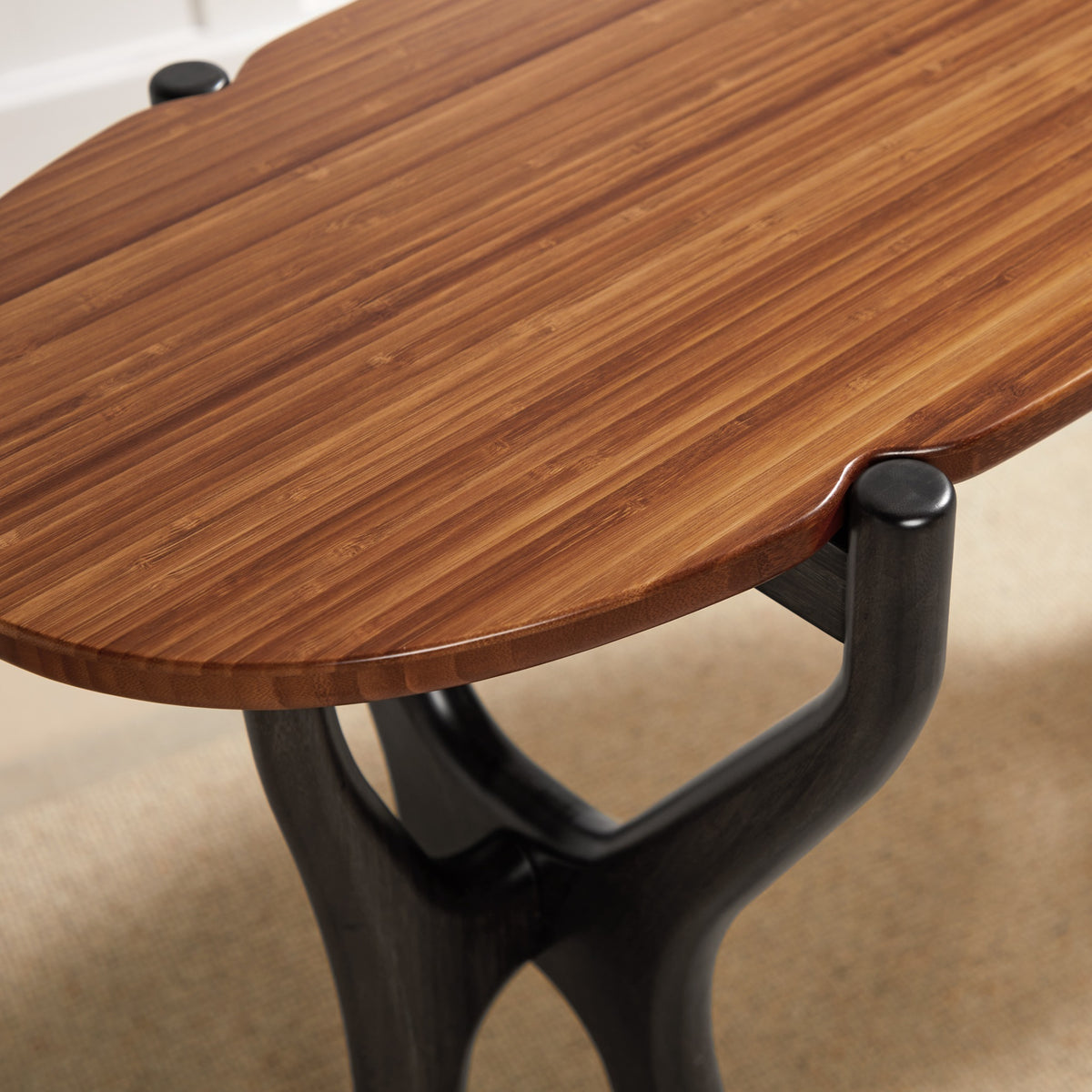 Close-up of the leg on the Greenington Tofino Console Table in Amber and Caviar bamboo