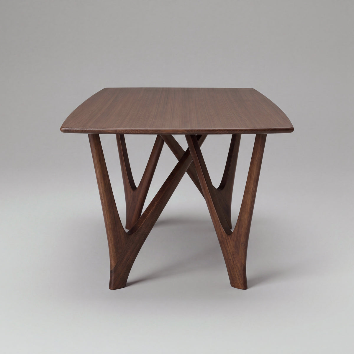 Greenington Vetra Dining Table in Black Walnut bamboo, on a studio backdrop, end view