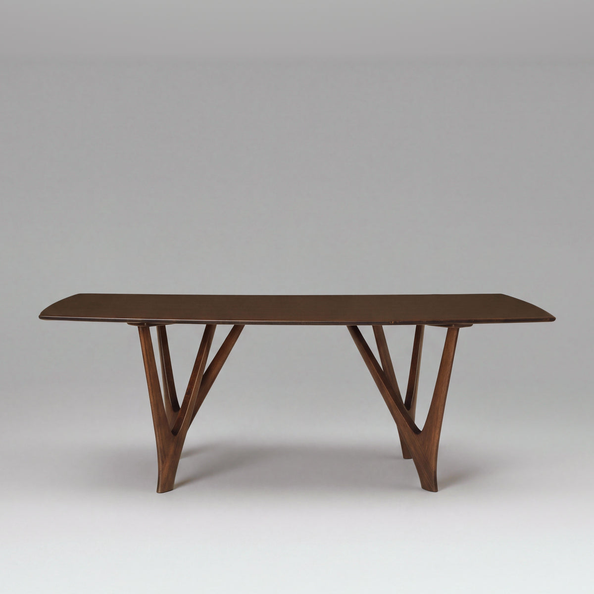 Greenington Vetra Dining Table in Black Walnut bamboo, on a studio backdrop, front view