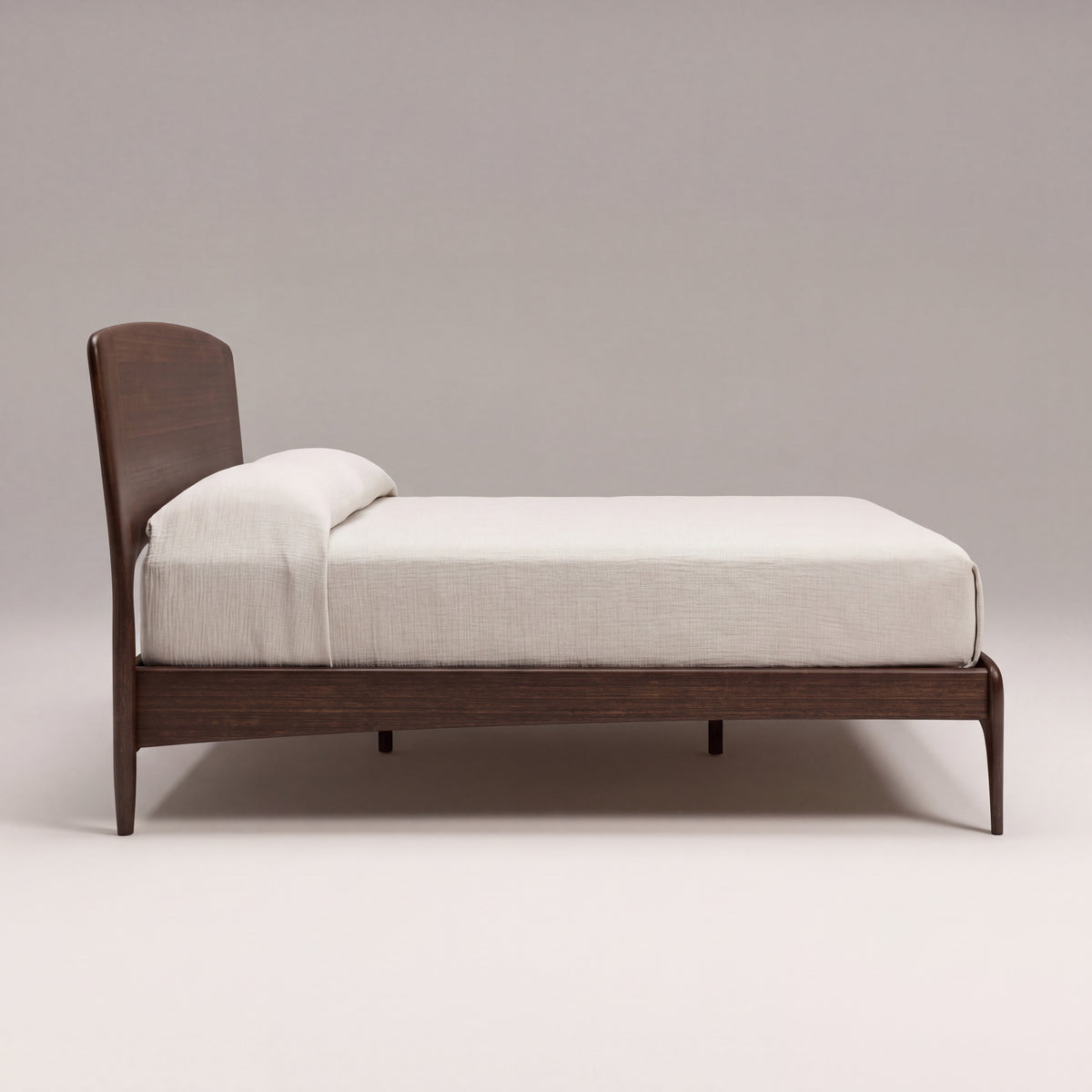 Greenington Zeva Platform Bed in Black Walnut bamboo with ivory linen bedding, on a light studio background, side view
